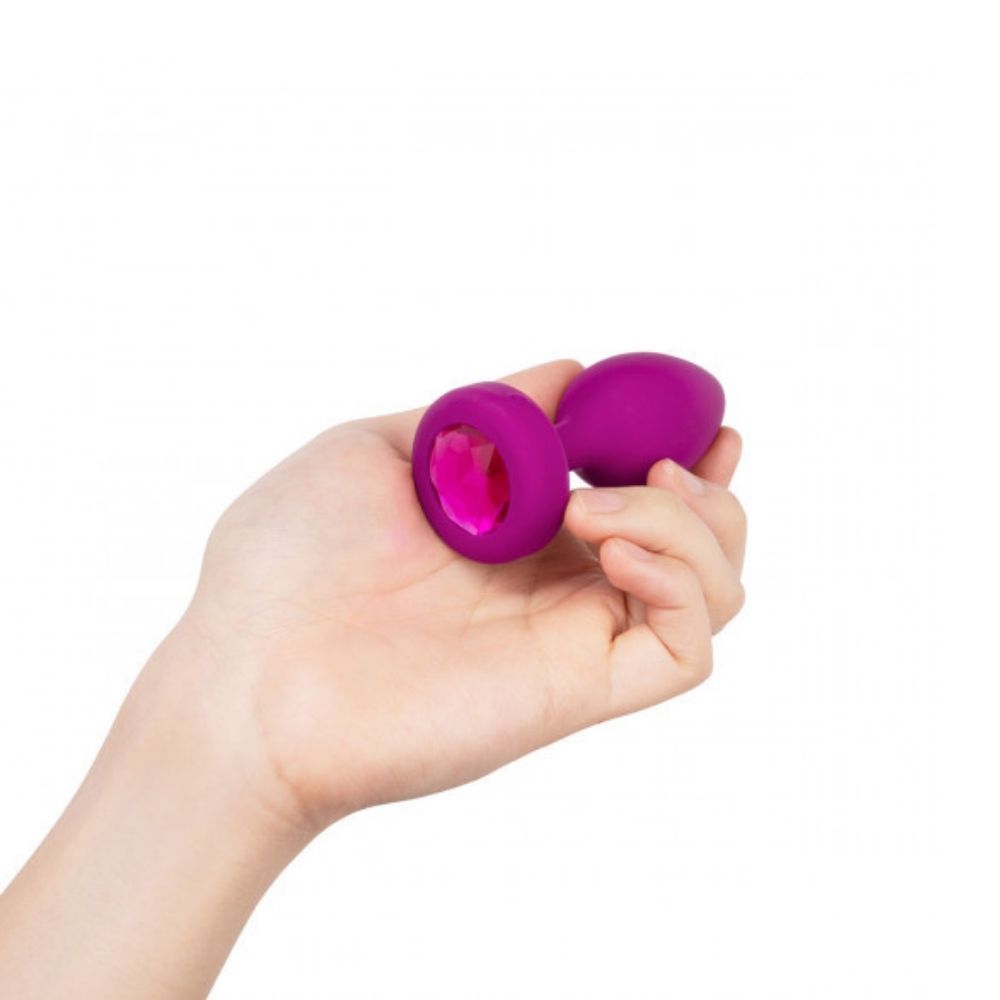 Fuchsia B-Vibe Vibrating Jewel Plug Small/Medium being held in hand showing the jewel base