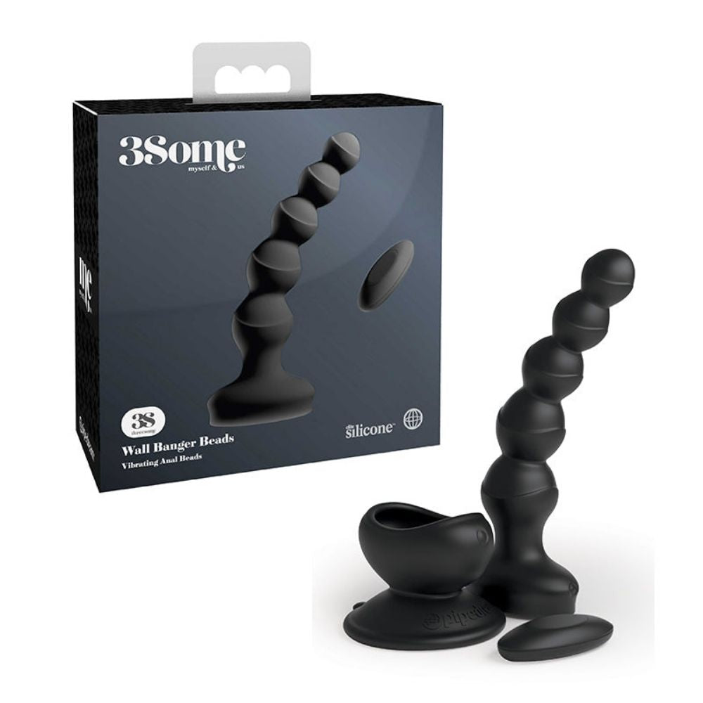 3Some Wall Banger Beads standing upright beside the suction cup base and remote control it comes with, in front of the box it comes in