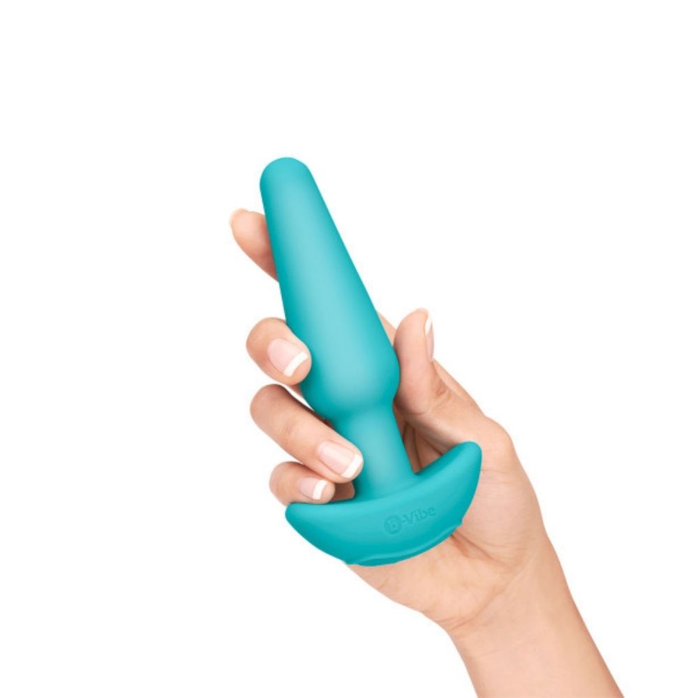 The medium vibrating butt plug included in the B-Vibe Anal Training Set, being held in a hand