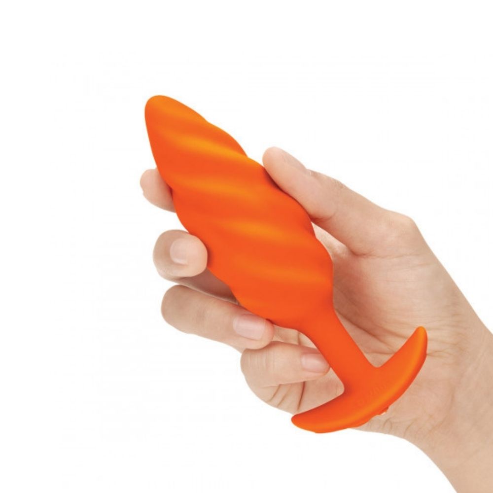 B-Vibe Texture Plug Swirl Orange (Medium) being held in hand