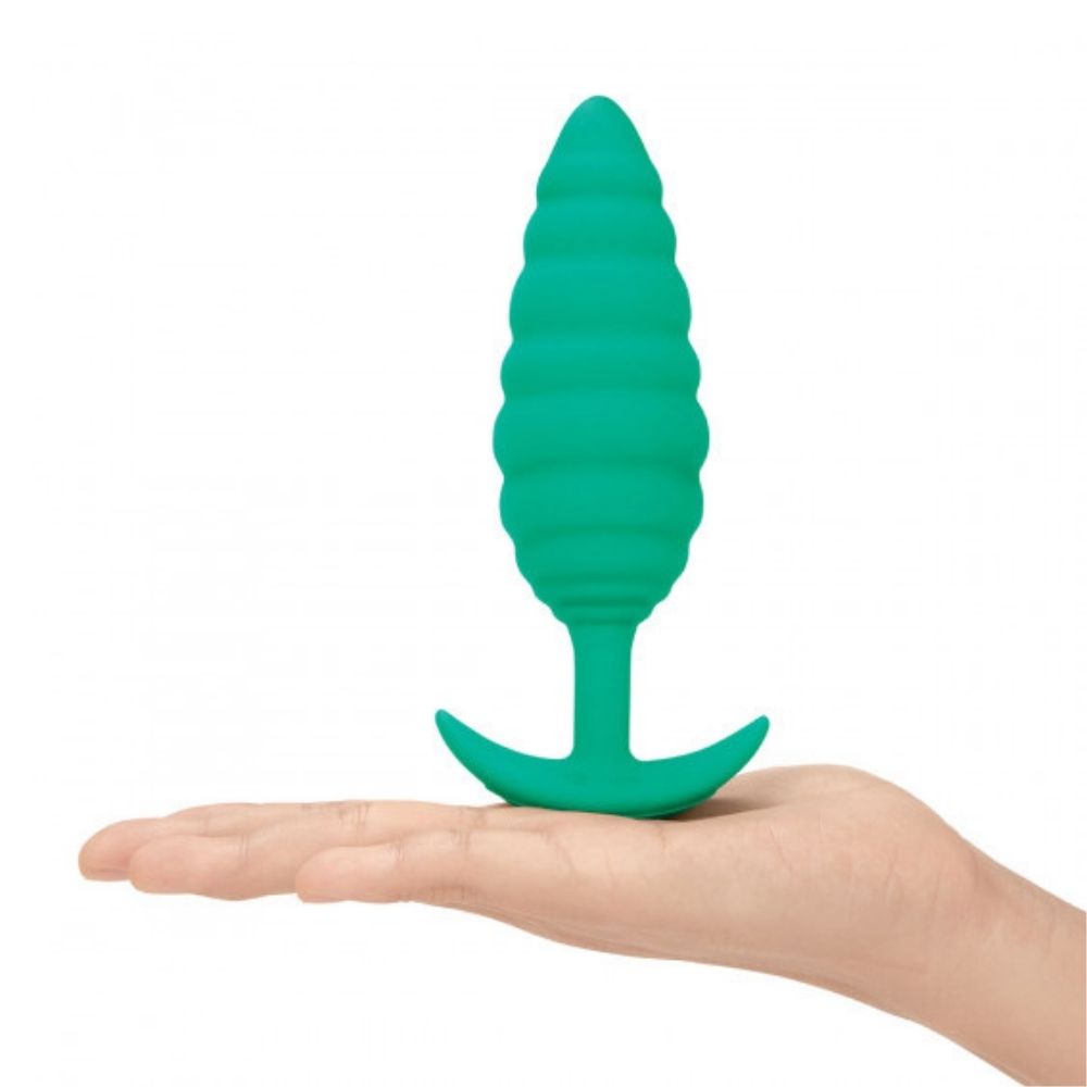 B-Vibe Texture Plug Twist Green (Large) standing on its base on top of the palm of a hand