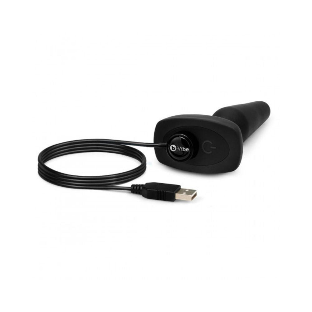 Black B-Vibe Trio Plug laying flat on its side with the charger plugged in its base