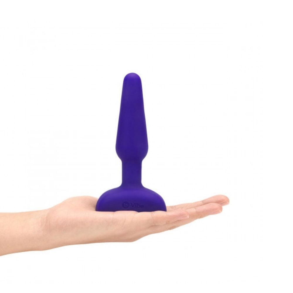 Purple B-Vibe Trio Plug standing on its base on top of the palm of a hand