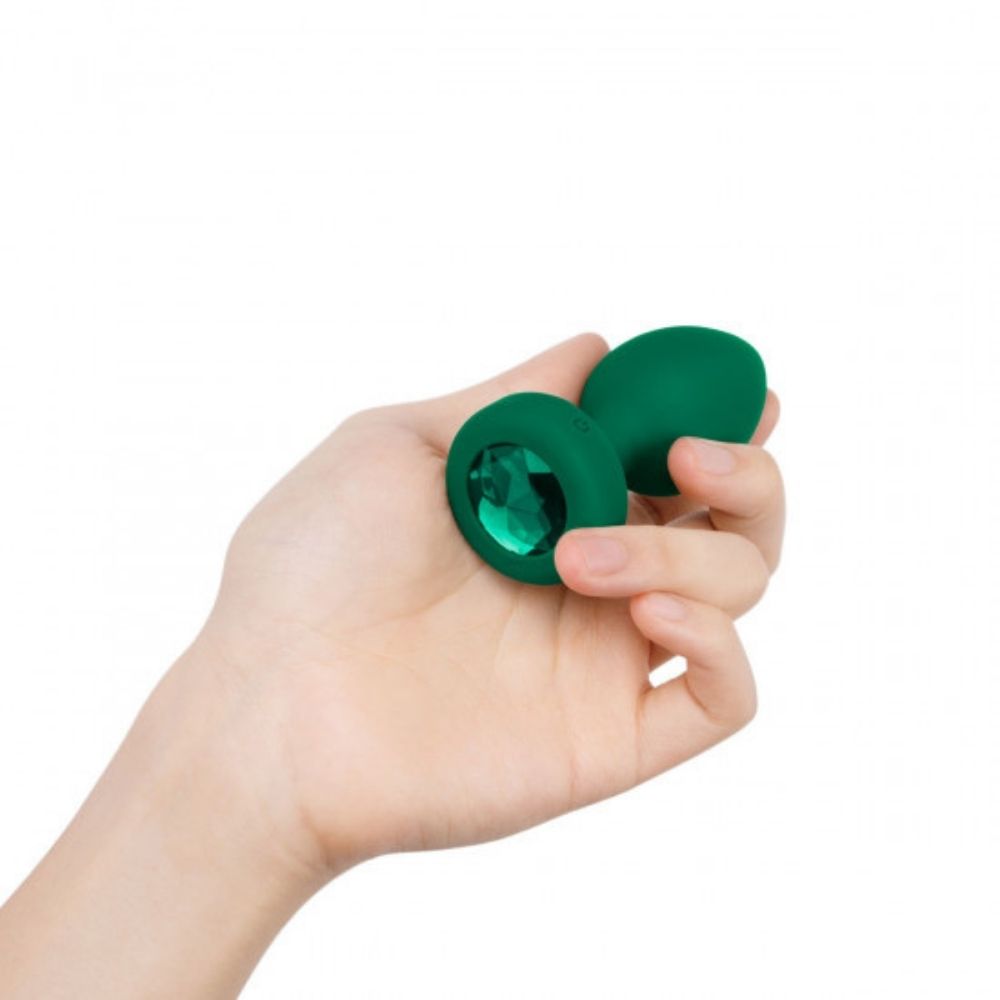 Emerald B-Vibe Vibrating Jewel Plug Medium/Large being held in hand showing the jewel base