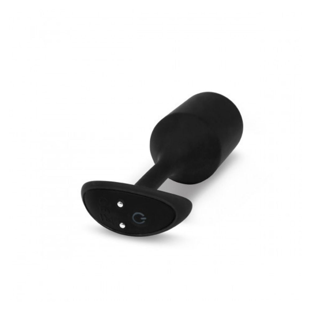 Black B-Vibe Vibrating Snug Plug 4 (XL) laying flat down on its side with the base in the forefront