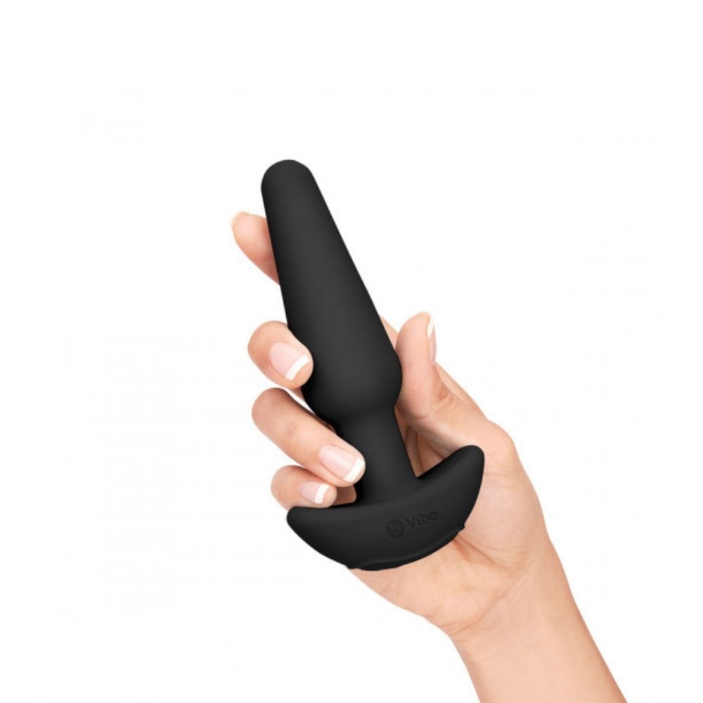 The medium vibrating butt plug included in the B-Vibe Anal Training Set, being held in a hand