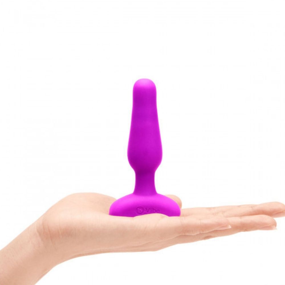 Fuchsia B-Vibe Novice Plug standing upright on the palm of a hand