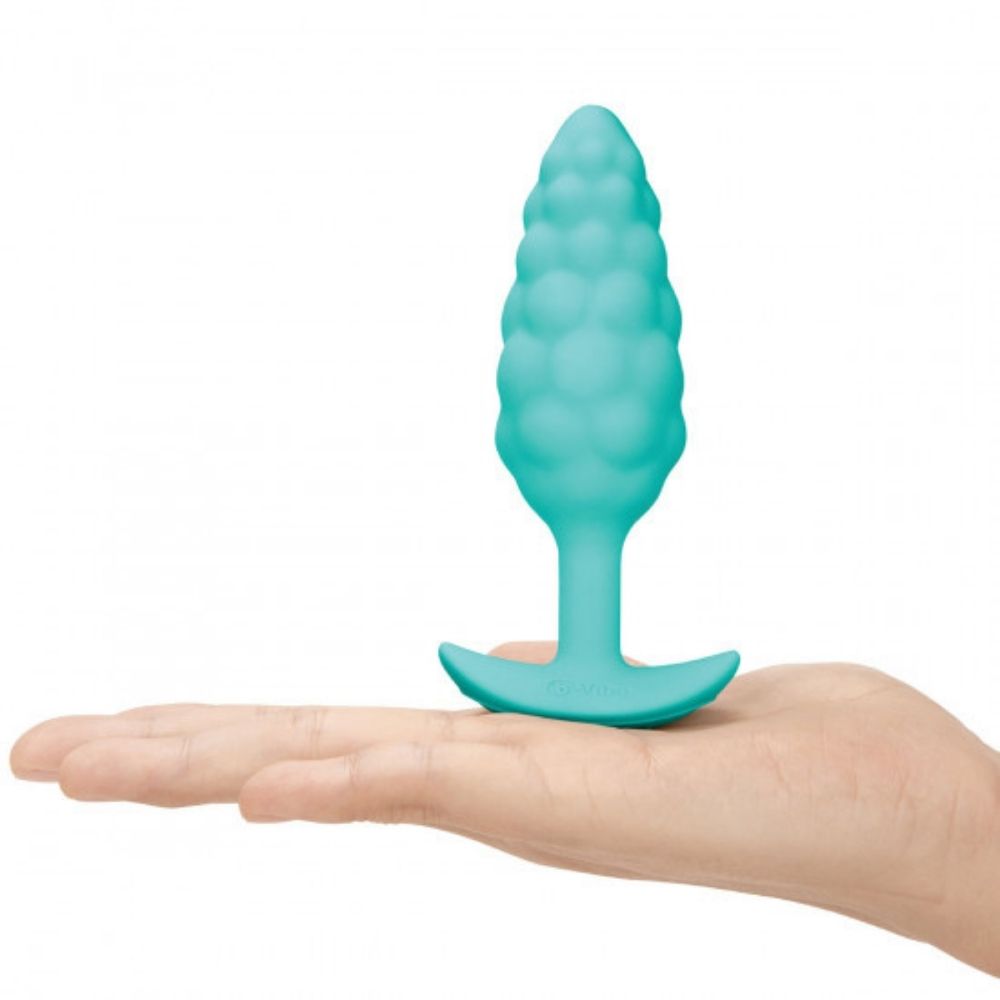 B-Vibe Texture Plug Bump Aqua (Small) standing on its base on top of the palm of a hand